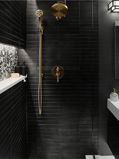 baño con alicatado en negro y grifería en bronce